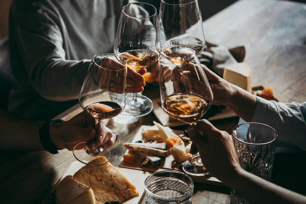 4 personnes qui trinques avec des verres de vins